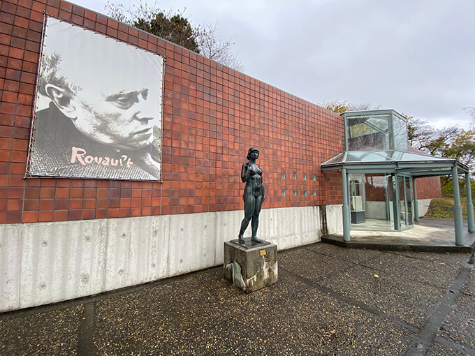 総ガラス張りのエントランスの左右に茜色のレンガの壁が伸びる清春白樺美術館。設計を手がけた谷口吉生の父、谷口吉郎も生前この地を訪れた。